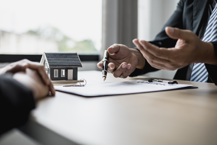 The employee is explaining the rent details and calculating the monthly rent to the tenant before signing the contract. The concept of renting a house.